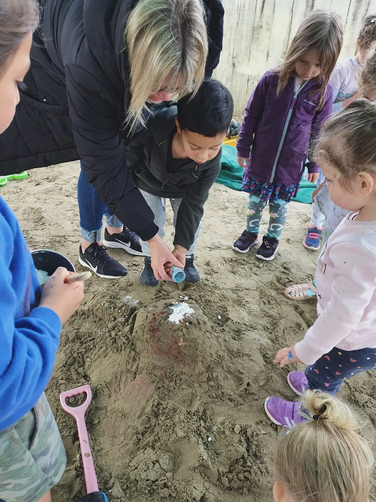 Children and teacher doing a volcano science experiment